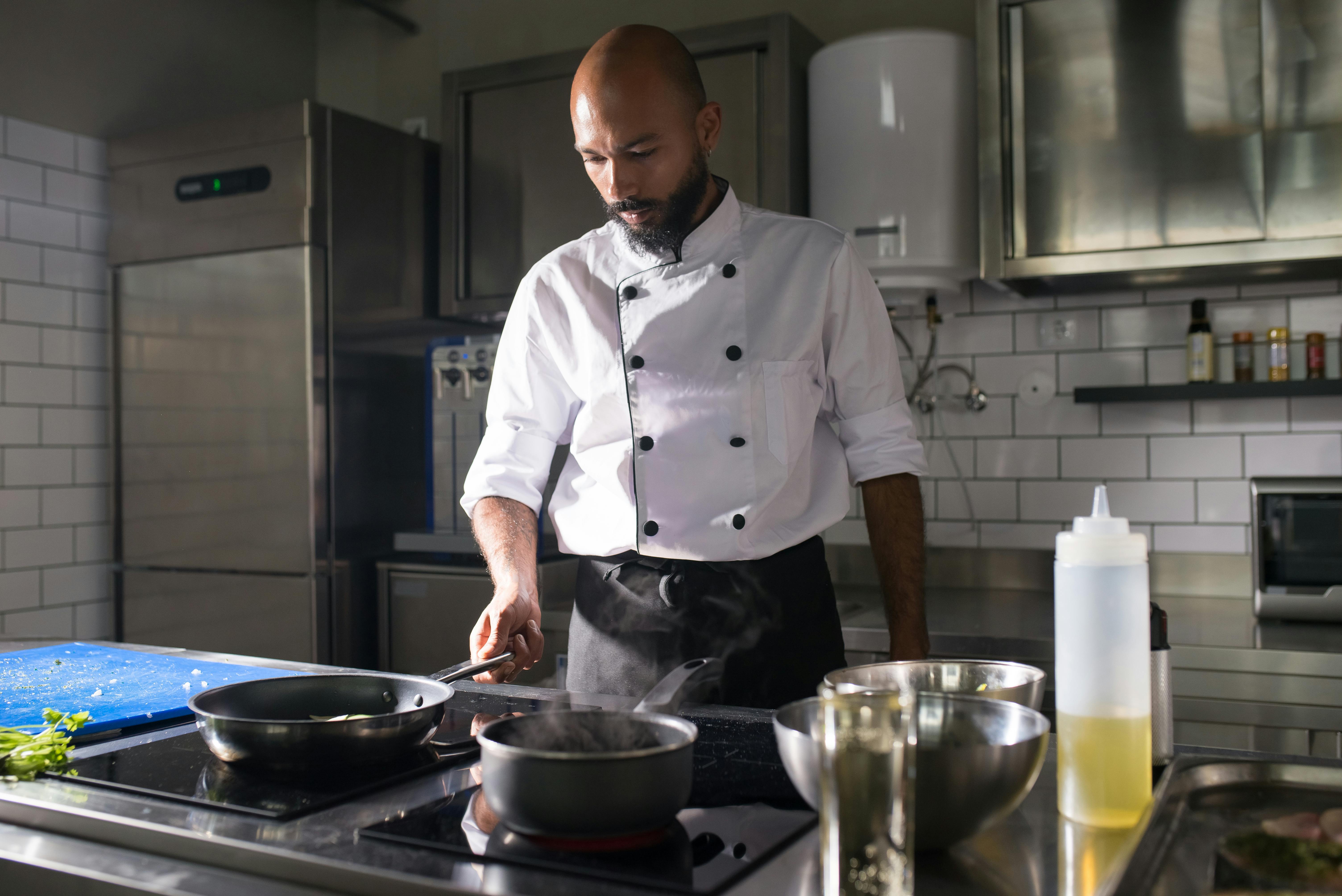 A chef meticulously plating a dish in a professional kitchen.